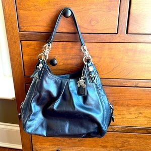 Black Coach bag with three compartments, zippers and magnetic closures.